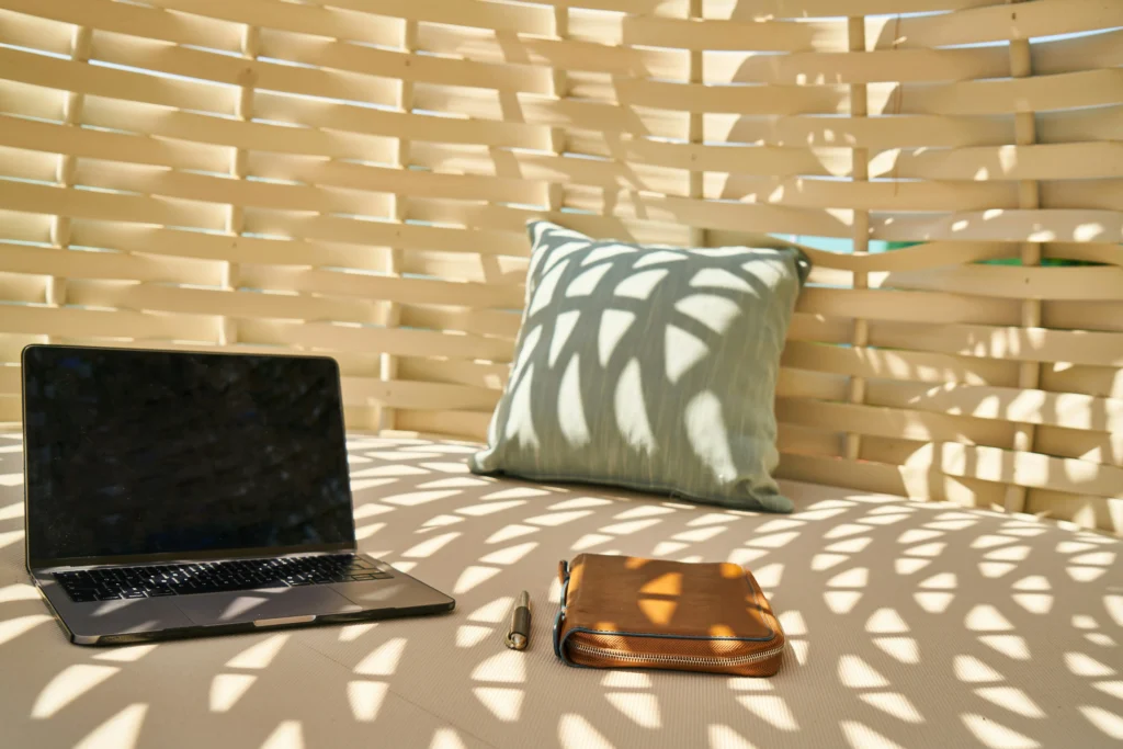 Labtop und Journal liegen in einem sonnendurchfluteten Strandkorb